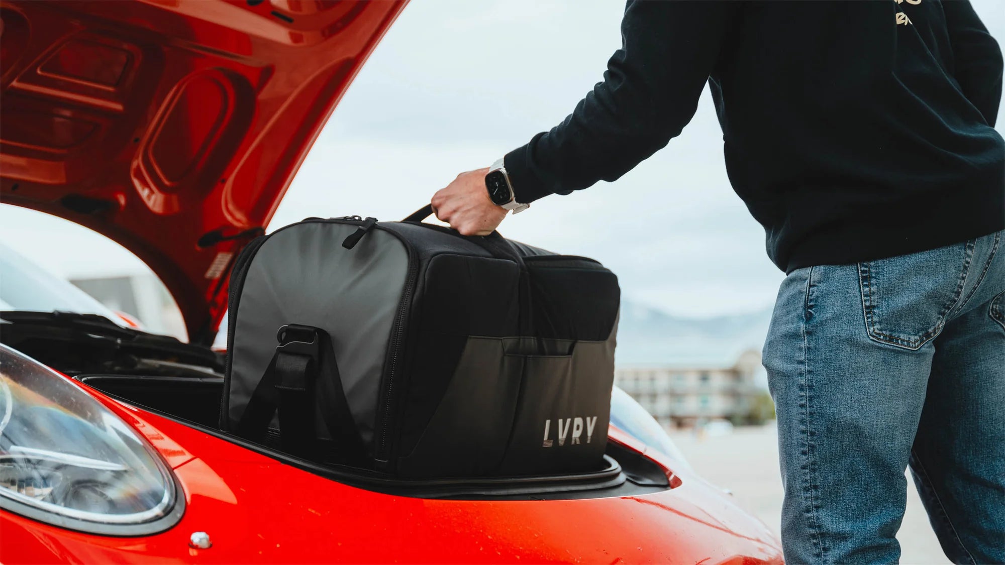 The LVRY CRRY Gear Bag from LVRY going into the trunk of red Porsche.